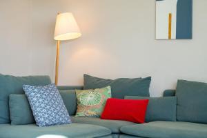 萨洛夫雷Villa mit Pool Los Lagos 16的蓝色的沙发,配有色彩缤纷的枕头和灯
