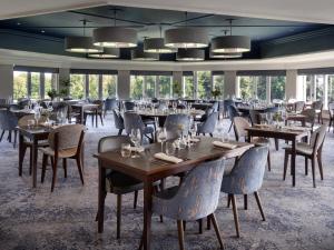 切普斯托Delta Hotels by Marriott St Pierre Country Club的用餐室设有桌椅和窗户。