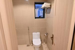利雅德Al Furat Madayin Hotel的浴室设有卫生间、镜子和窗户。