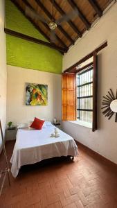 圣玛尔塔Maria Mulata Boutique Hotel的一间卧室设有一张带绿色墙壁和窗户的床。