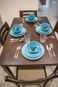 格兰德海滩Skyline Suites Grenada的一张带蓝色板子和银器的木桌