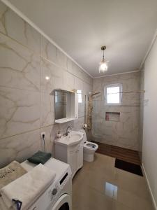 奥拉迪亚Casa de langa lac的白色的浴室设有水槽和卫生间。