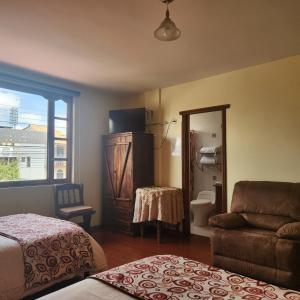 里奥班巴Hotel Bella Casona的一间卧室配有一张床、一张沙发和一面镜子