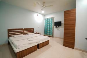 斋浦尔HOTEL ATHITI INN JAIPUR的一间卧室配有一张床和一台电视