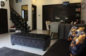 拉合尔Vacation Villa的客厅配有黑色搁脚凳和沙发
