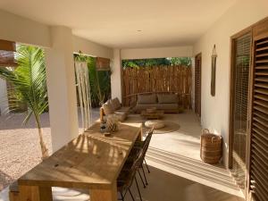 克拉伦代克Isla penthouse & garden apartments Bonaire的客厅配有木桌和椅子
