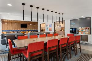 亚特兰大Holiday Inn Express Atlanta Airport - North, an IHG Hotel的一间带大桌子和红色椅子的用餐室