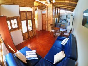 洛斯拉甘斯Casa Mauka Bungalow的一间带蓝色沙发的客厅和一间厨房
