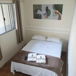 瓜鲁柳斯Lá Casa do Manguinha的一间卧室配有一张床,上面有两条毛巾
