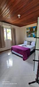 莫罗圣保罗Vista Verde的一间卧室配有一张带紫色毯子的床
