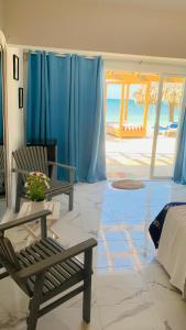 蓬塔露奇亚La Isla Bonita的一间设有两把椅子和一张床及蓝色窗帘的房间
