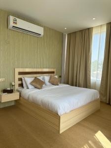 尼兹瓦Al ATLAL apartment的一间卧室配有一张大床和空调