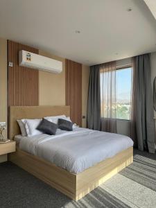 尼兹瓦Al ATLAL apartment的一间卧室设有一张大床和一个窗户。