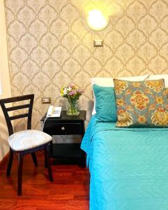 昆卡HOSTAL EL CAJAS的一间卧室配有一张床和一张桌子及椅子