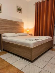 莫斯塔尔Lovely Bosnian Home的卧室内的一张大床,配有橙色窗帘