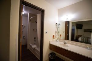 西黄石Mountain Vista Hotel的一间带水槽和大镜子的浴室