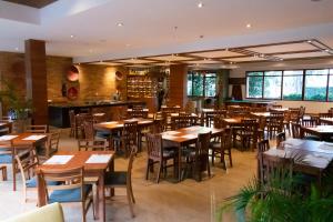 波哥大Hotel Habitel Select的一间带木桌椅的餐厅和一间酒吧