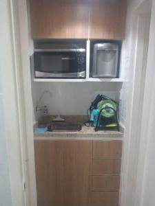 里约热内卢Apartamento ao lado do metro da Cinelândia e Consulado Americano的带微波炉和水槽的小厨房