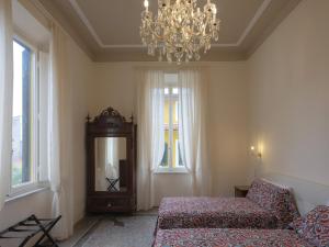 维亚雷焦Villa Giulia BnB的一间带沙发、镜子和吊灯的卧室