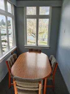 皇后镇Lakeside Backpackers的带2扇窗户的客房内的木桌