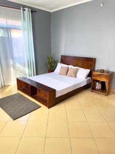 达累斯萨拉姆Sally's home-near JNIA airport的一间卧室配有一张木架大床