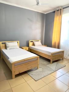 达累斯萨拉姆Sally's home-near JNIA airport的带窗户的客房内设有两张单人床。