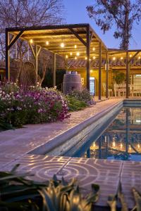 圣克鲁兹Hotel Hoja de Parra的泳池旁的凉亭配有灯和鲜花