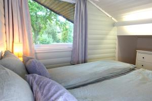 卑尔根Villa Arboretet - Seaside villa with private pool & infrared sauna in the heart of Arboretet, Bergen的一间卧室配有一张带窗户的床