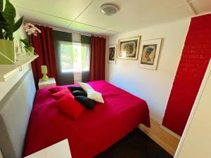 特雷勒堡Lovely cottage by the south coast的一张红色的床,里面有两个枕头