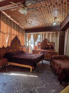 San AntonioLA CASA DE LOS MANGOS AJIJIC的一间卧室配有两张床和吊扇