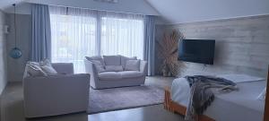 卢甘维尔Bombua Beach House的客厅配有2把椅子和平面电视