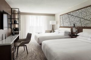 奥兰多Marriott Orlando Airport Lakeside的酒店客房配有两张床和一张书桌