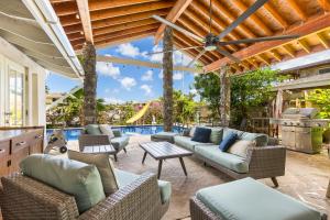 檀香山Tranquil Marina Front Pool House Resort的带家具的户外庭院和游泳池