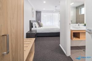 莫鲁亚Hive Hotel, Moruya的一间卧室配有一张床,浴室设有水槽