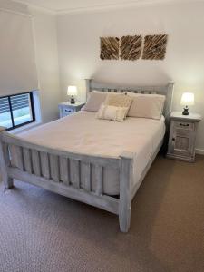 卡尔布拉海滩Ranges Over the Bay的一间卧室配有一张大床、两张桌子和两盏灯。