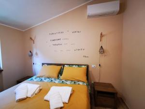 LA CASA DEL GRILLO - Valle del Menotre - Rasiglia的一间卧室配有一张床,上面有两条毛巾