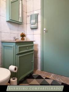 格拉玛多Casinha de Gramado的一间带绿色橱柜和卫生间的浴室