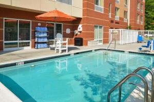 巴尔的摩怀特马什费尔菲尔德旅馆&套房酒店的一座带遮阳伞的游泳池位于大楼旁