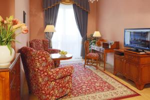 卡罗维发利布里斯托尔酒店的客厅配有椅子和电视