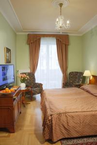 卡罗维发利布里斯托尔酒店的一间卧室配有一张床、一台电视和一把椅子