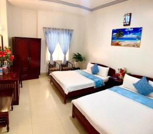 河仙都洪2号酒店的酒店客房带两张床和一张桌子以及椅子。