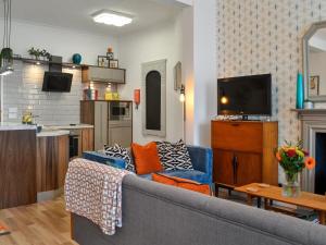 WhithornGeorge Apartment 54的一间带蓝色沙发的客厅和一间厨房