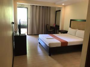 奥隆阿波苏比克大海度酒店的一间卧室配有一张床、一张书桌和一个窗户。