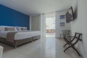 圣安德烈斯Hotel San Luis Beach House的一间卧室配有一张床,墙上配有电视