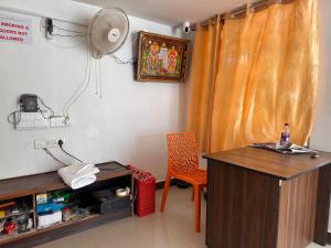 蒂鲁瓦纳马莱MPS Saai Residency的客房配有书桌、椅子和风扇。