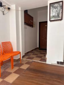 蒂鲁瓦纳马莱MPS Saai Residency的一个空房间,有橙色椅子和门