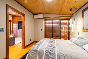 Cottonwood HeightsThe Cottonwoods Ski Cabin的一间卧室设有一张带木制天花板的大床