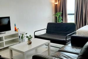 普崇mozhouze studio @ 8 Kinrara Service Apartment的客厅配有沙发、椅子和电视