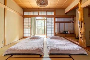 松本一組限定の貸切空間 Guest House Engiya的带窗户的客房内的两张床