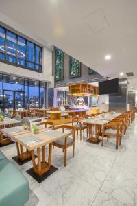 当格浪THE 1O1 Jakarta Airport CBC的餐厅设有木桌、椅子和窗户。